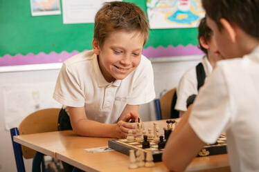 Two students playing Chess in class