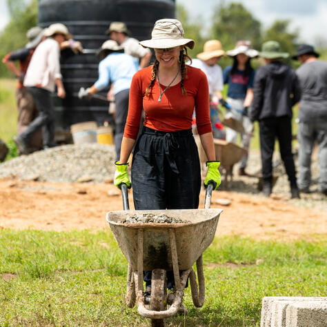 student carrying a wheelbarrow