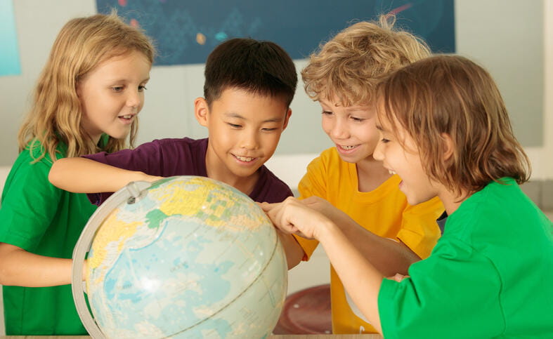 Students gathering around a globe