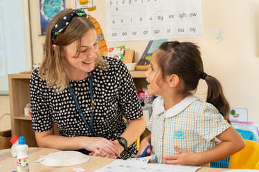 Teacher and student seated at a table