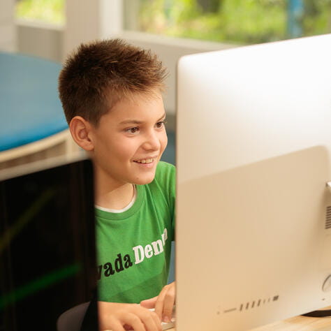 A student seated in front of a desktop computer